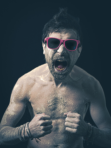 Portrait photographique d’Olivier Giner réalisé par le photographe Henri Aubron, ambiance sombre et punk avec lunettes roses